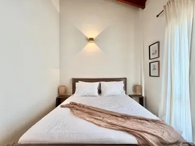 a bedroom with a bed with a light on the wall at The Yard Residence in Gavalochori