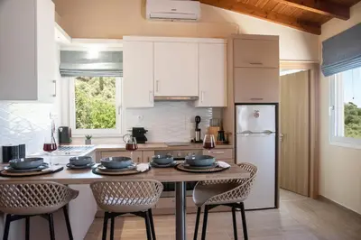 a kitchen with a table and chairs and a refrigerator at Villa Noelia in Rogdhiá