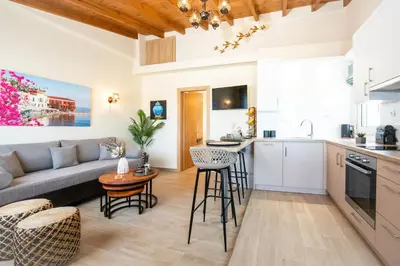 a kitchen and living room with a couch and a table at Villa Noelia in Rogdhiá