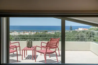 a group of chairs sitting on a balcony at Seaview villa with pool in nature next to Platanias in Plataniás