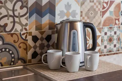 a coffee pot and three cups on a counter at Manolis Stone House Villa in Mouríon