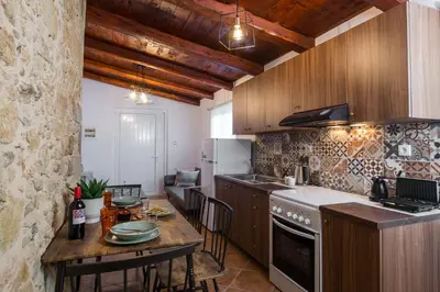 a kitchen with a table and a counter top at Manolis Stone House Villa in Mouríon