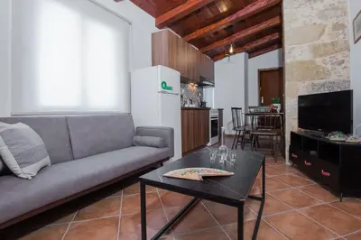 a living room with a couch and a table at Manolis Stone House Villa in Mouríon