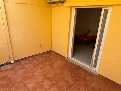 an empty room with a door and a tiled floor at Michalis Studios & Aparntments in Palaiochóra