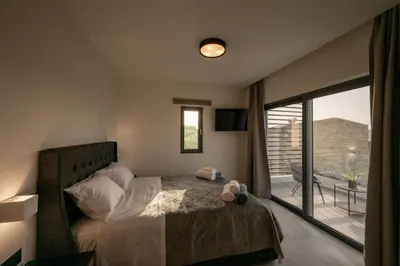 a bedroom with a bed and a large window at Villa Icons in Agia Marina Nea Kydonias