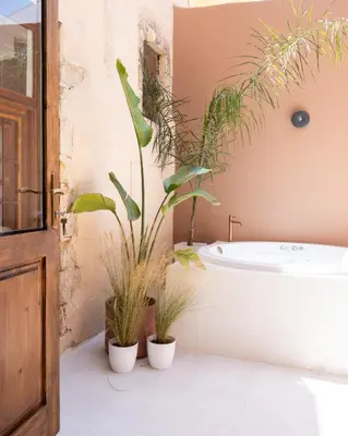 a bathroom with potted plants and a bath tub at Qualia Slowlife Suites in Chania Town
