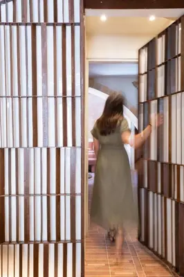 a woman in a dress walking through a library at Qualia Slowlife Suites in Chania Town