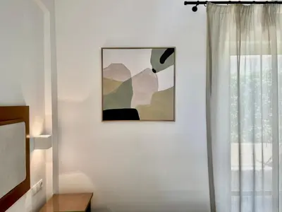 a room with a picture on the wall and a window at Harbour Studios And Apartments in Palaiochóra