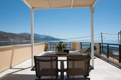a patio with a table and chairs on a balcony at Harbour Studios And Apartments in Palaiochóra