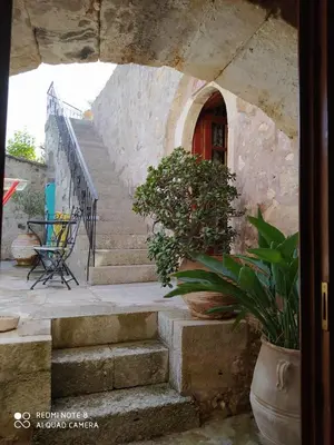a set of stairs leading to a red door at Charmante maison crétoise à Embrosneros in Embrósneros