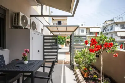 a balcony with a table and chairs and flowers at Clio - Newly renovated Home with Parking in Chania Town