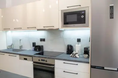 a kitchen with white cabinets and a microwave at Benessere in Chania Town