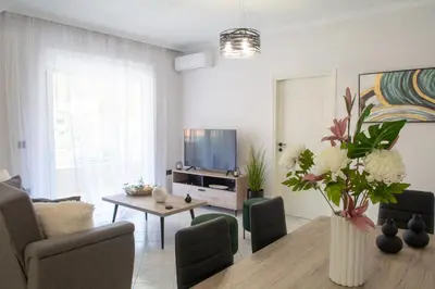 a living room with a table and a vase of flowers at Benessere in Chania Town