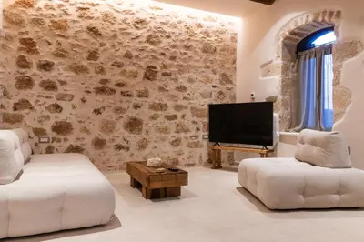a living room with a tv and a couch and a table at Delta-Rho in Kalami