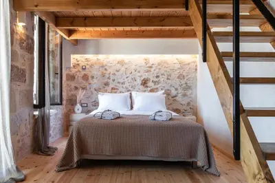a bedroom with a bed with a wooden floor at Delta-Rho in Kalami
