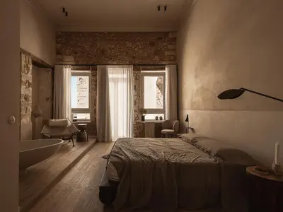 a bedroom with a bed and a tub and a bathroom at Aisha Hotel in Chania Town