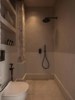 a bathroom with a white toilet and a shower at Aisha Hotel in Chania Town
