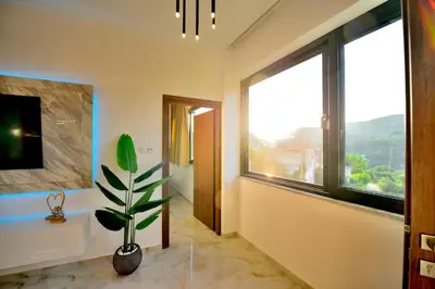 a bathroom with a large window and a potted plant at Anatoli Apartment in Kissamos