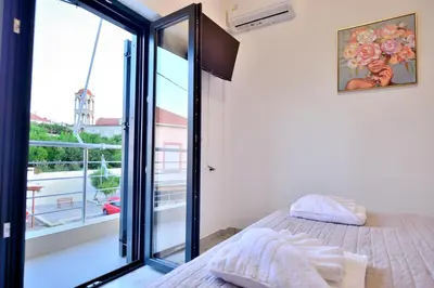 a bedroom with a bed and a balcony at Anatoli Apartment in Kissamos