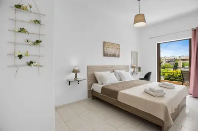 a white bedroom with a bed and a window at Seafront Apartment in Chania 7 in Chania Town