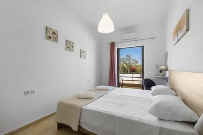 a white bedroom with a large bed and a window at Seafront Apartment in Chania 7 in Chania Town