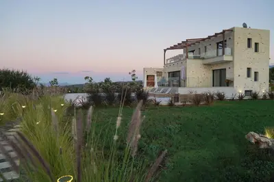 a house on top of a grassy field at Afea Villas in Plataniás