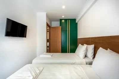 two beds in a room with a tv on the wall at Modern Dream Apartment in Plataniás