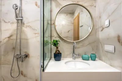 a bathroom with a sink with a mirror and a shower at Modern Dream Apartment in Plataniás