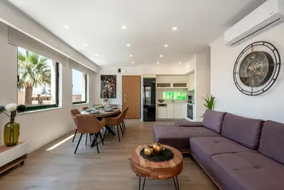 a living room with a purple couch and a table at Modern Dream Apartment in Plataniás