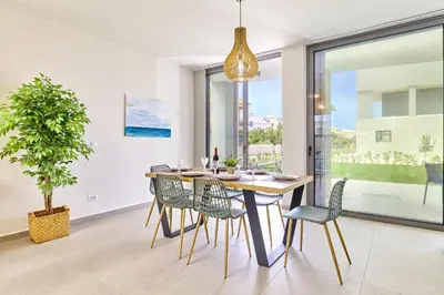 a dining room with a table and chairs and a potted plant at Beach Sand Villas - Beachfront Roof Pool Seaviews in Pírgos Psilonérou