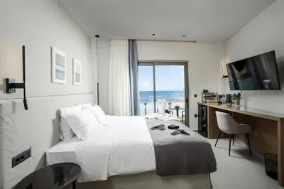 a bedroom with a bed and a desk and a television at Iria Sea View Room in Kolymvari