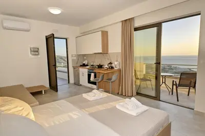 a room with a bed and a kitchen with a view at Rosmari Studios in Falasarna