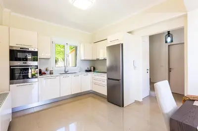 a kitchen with white cabinets and a stainless steel refrigerator at Harmony Villa in Chania Town