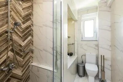 a bathroom with a toilet and a glass shower at Harmony Villa in Chania Town
