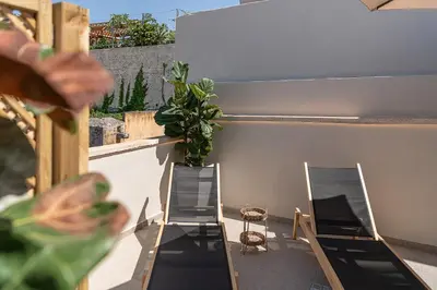two chairs and a potted plant on a balcony at Steki Luxury Room 3 in Chania Town