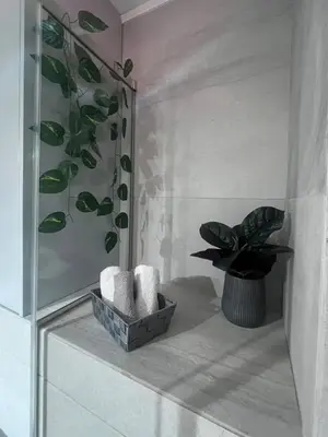 a bathroom with a plant and towels on a shelf at Petra's Charming Home, 500m to Beach in Chania Town