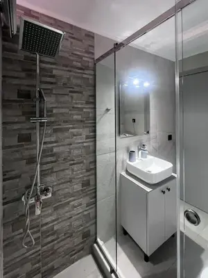 a bathroom with a sink and a glass shower at Petra's Charming Home, 500m to Beach in Chania Town