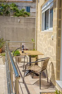 a patio with two tables and chairs on a balcony at Petra's Charming Home, 500m to Beach in Chania Town