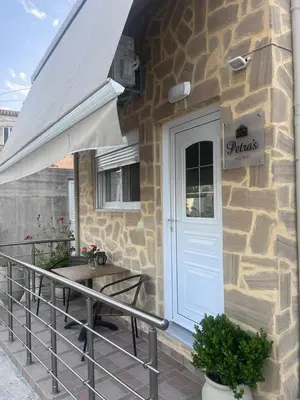 a stone building with a patio with a white door at Petra's Charming Home, 500m to Beach in Chania Town
