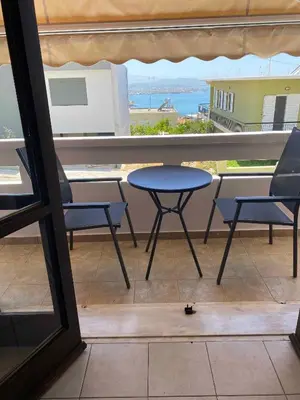 a patio with a table and chairs on a balcony at Eolia apartment in Chania with Sea&City View in Chania Town