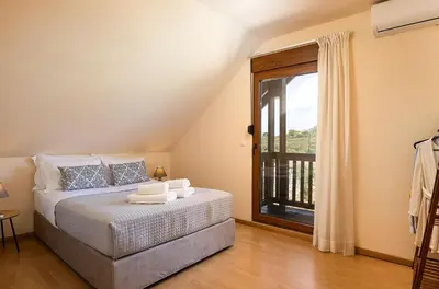 a bedroom with a bed and a large window at Olive Garden Villa 5 min from Golden Beach in Galatás