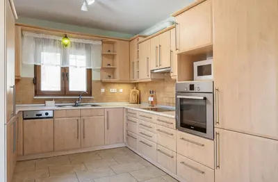 a kitchen with wooden cabinets and stainless steel appliances at Olive Garden Villa 5 min from Golden Beach in Galatás