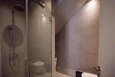 a shower with a glass door in a bathroom at ARCH HOME, luxury property with private parking in Chania Town