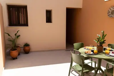 a dining room with a green table and chairs at ARCH HOME, luxury property with private parking in Chania Town