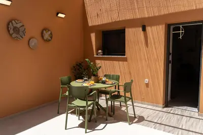 a dining room with a table and green chairs at ARCH HOME, luxury property with private parking in Chania Town