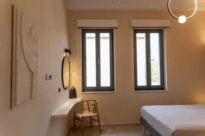 a bedroom with a sink and a bed and windows at ARCH HOME, luxury property with private parking in Chania Town