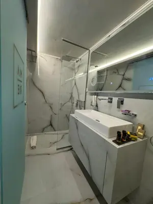 a white bathroom with a sink and a mirror at mare suites 4 in Chania Town