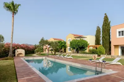 a villa with a swimming pool and palm trees at Aloni Grove Retreat in Chania Town