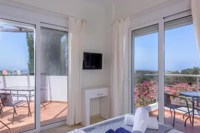 a bedroom with a view of a balcony with a table at Aloni Grove Retreat in Chania Town
