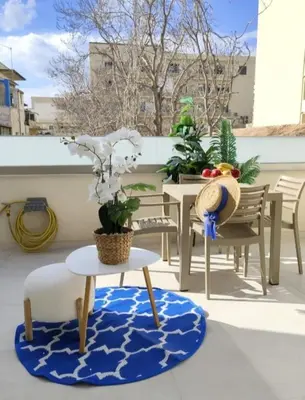 a patio with a table and chairs and a rug at Cherry Central Luxury Suites in Chania Town